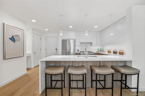 a kitchen with kitchen island a appliances dining table and chairs