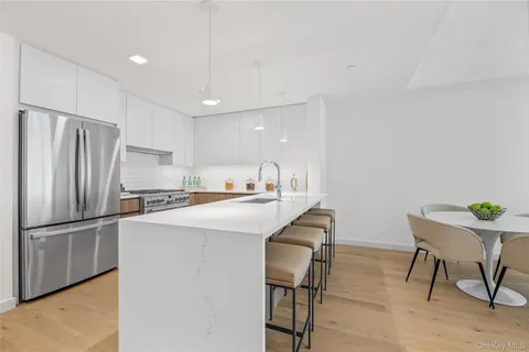 a large kitchen with a sink and a refrigerator