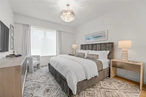 a bedroom with a bed and a chandelier