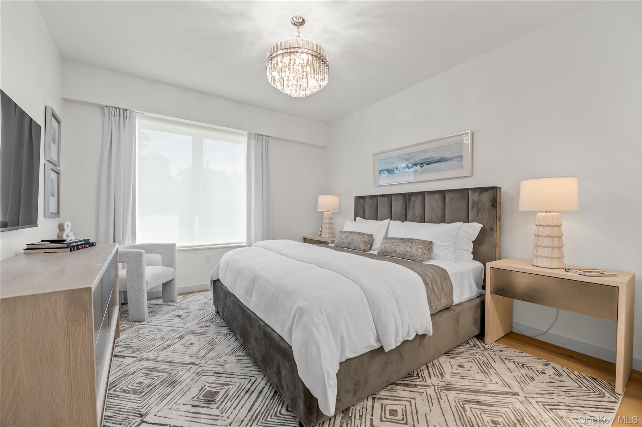 218 Middle Neck Road, Unit 207 Great Neck, NY 11021 - Photo 25 of 32 a bedroom with a bed and a chandelier