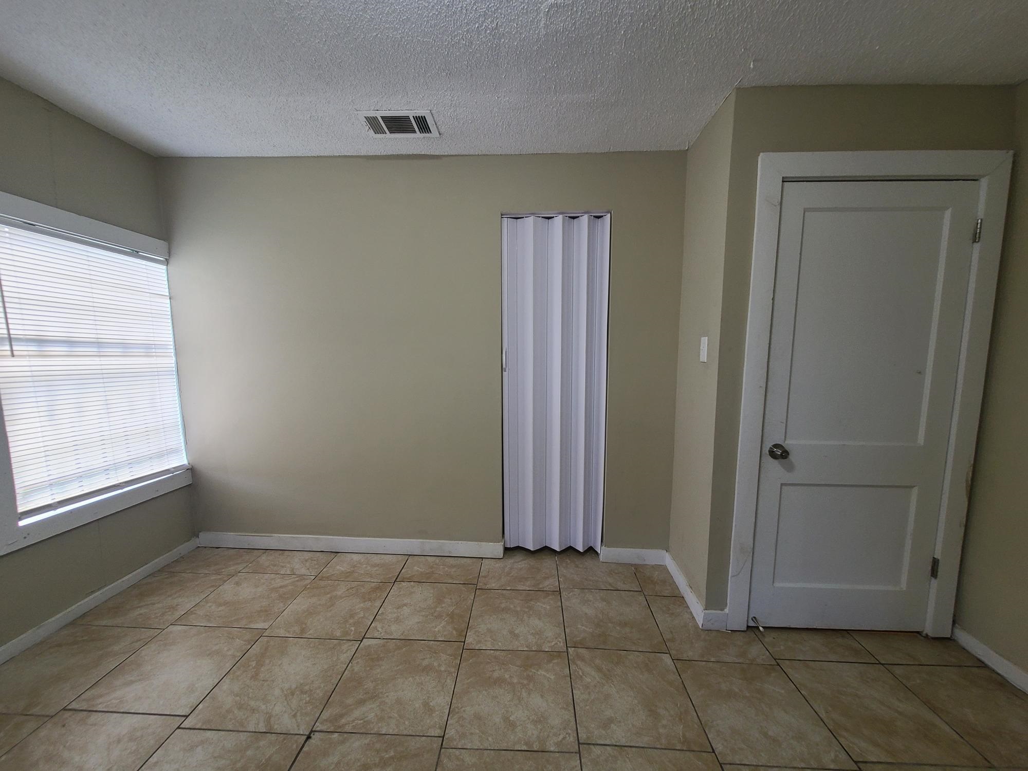 731 Flynn Road Memphis, TN 38109 - Photo 10 of 15 Tile flooring, window with blinds, bi-fold closet door, and a paneled interior door