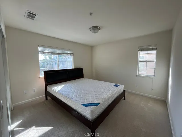 a bed sitting in a bedroom next to a window