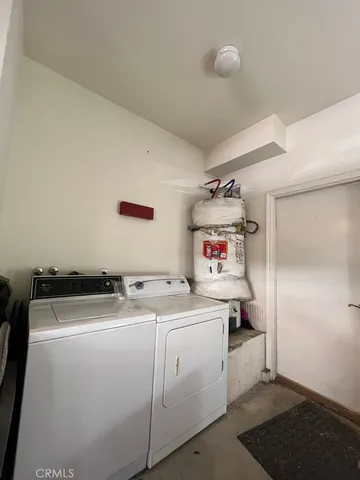 a white house that has a small yard and a large parking space