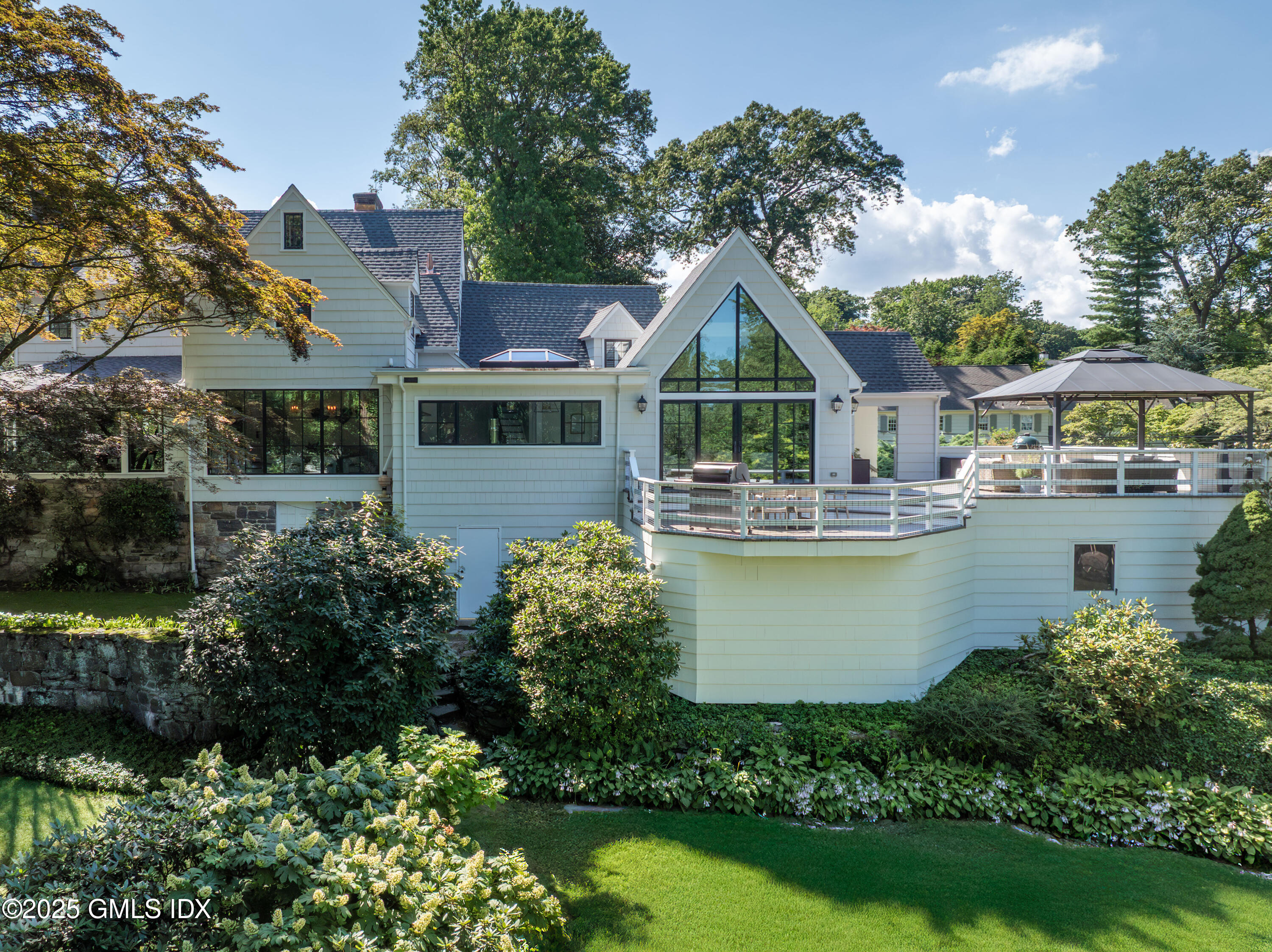 87 Orchard Drive Greenwich, CT 06830 - Photo 1 of 31 a front view of a house with garden and lake view