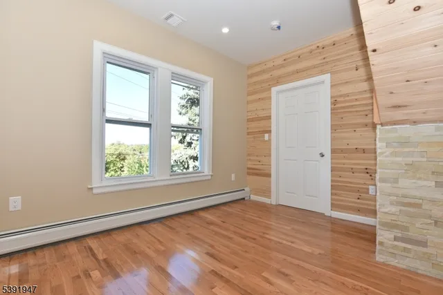a view of empty room with wooden floor and fireplace