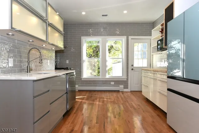 a kitchen with a sink a wooden floor and a large window