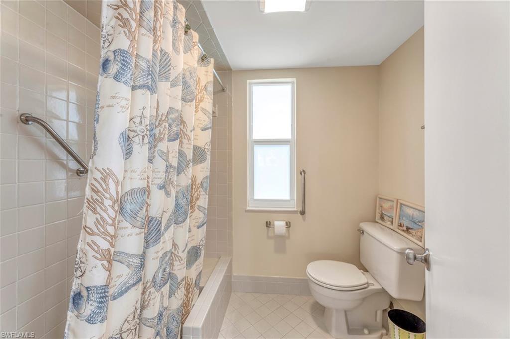 245 Quails Nest Road, Unit 3 Naples, FL 34112 - Photo 24 of 50 a white toilet sitting next to a shower curtain