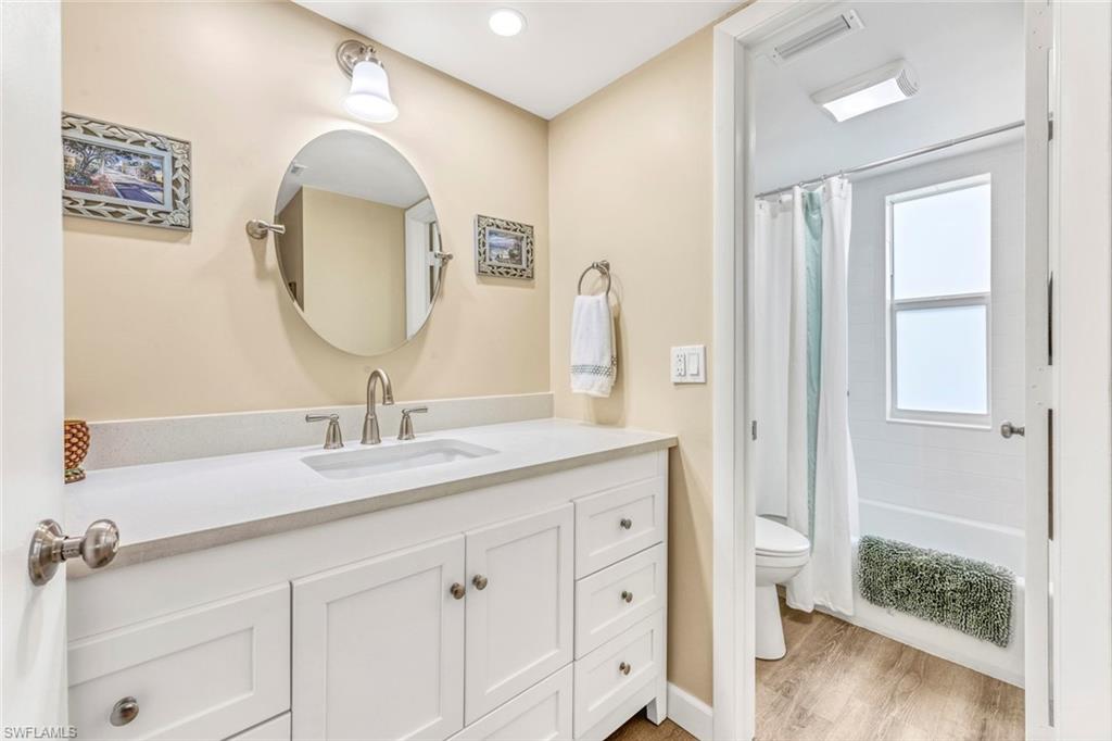 245 Quails Nest Road, Unit 3 Naples, FL 34112 - Photo 27 of 50 a en suite bathroom with a granite countertop sink and a mirror