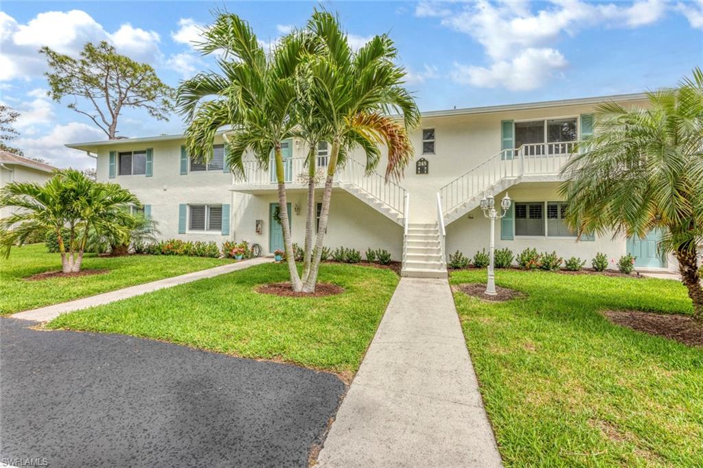 245 Quails Nest Road, Unit 3 Naples, FL 34112 - Photo 3 of 50 a front view of a house with a yard and potted plants