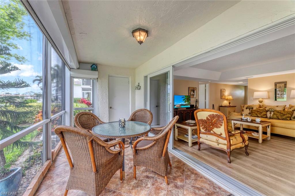 245 Quails Nest Road, Unit 3 Naples, FL 34112 - Photo 31 of 50 a dining room with furniture wooden floor and a rug