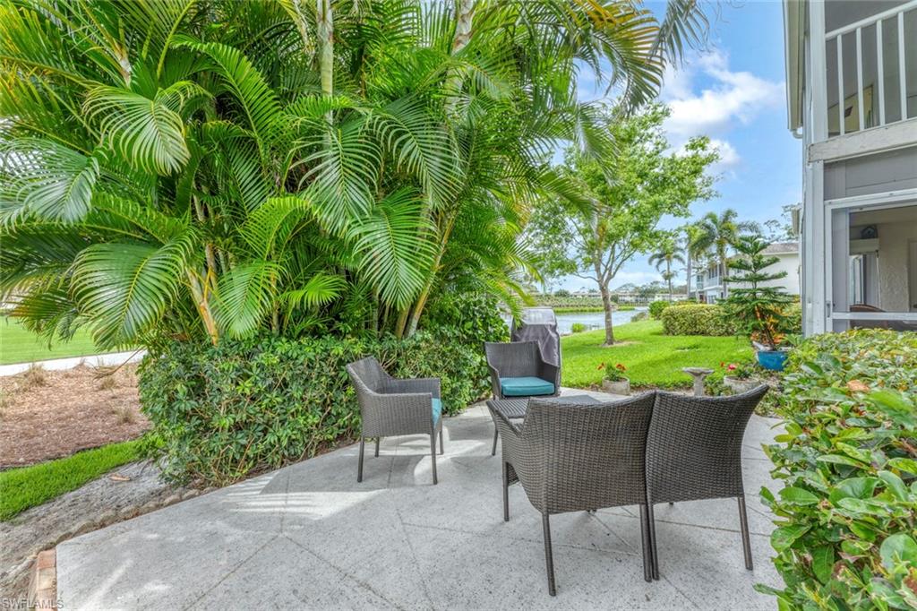 245 Quails Nest Road, Unit 3 Naples, FL 34112 - Photo 33 of 50 a view of a patio with table and chairs and potted plants