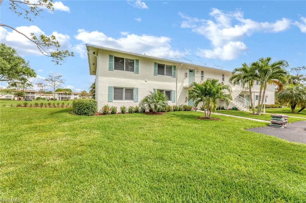 245 Quails Nest Road, Unit 3 Naples, FL 34112 - Photo 4 of 50 a front view of house with yard and lake view