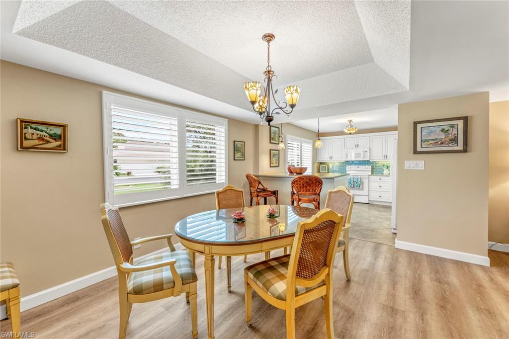 245 Quails Nest Road, Unit 3 Naples, FL 34112 - Photo 8 of 50 a dining room with furniture a chandelier and window