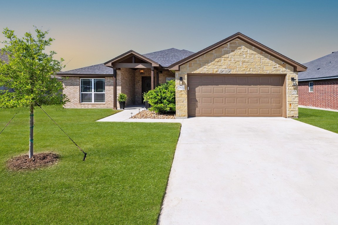 a front view of a house with a yard and garage