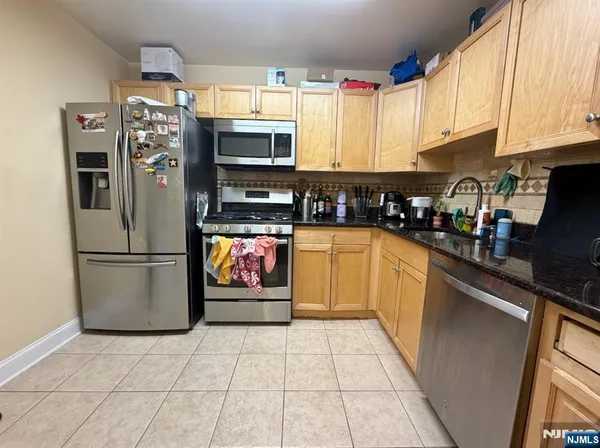a kitchen with stainless steel appliances granite countertop a refrigerator sink and microwave