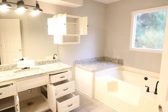 a bathroom with a granite countertop sink and a mirror