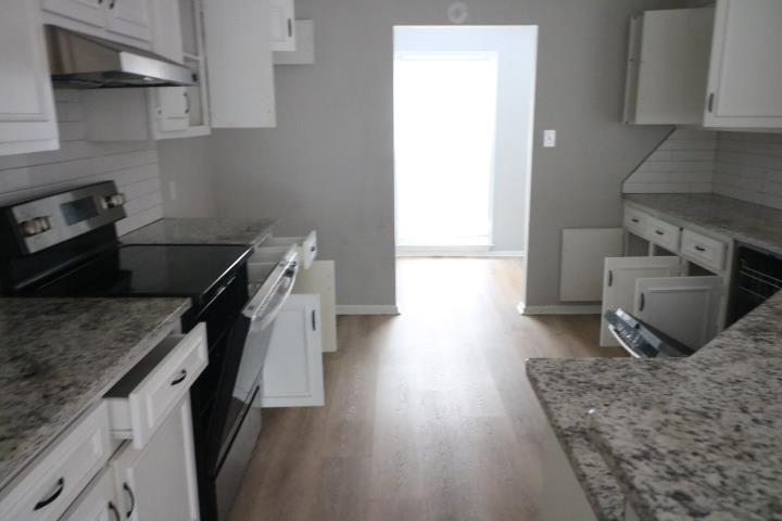 7935 Crescent Drive Columbus, GA 31909 - Photo 5 of 16 a kitchen with a wooden floor and a stove top oven