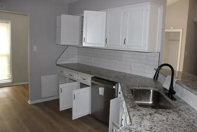 a kitchen with stainless steel appliances granite countertop a stove a sink and a microwave