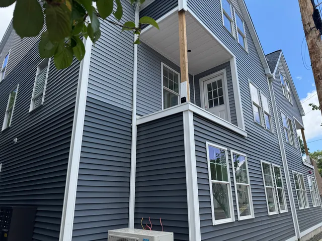 a view of a house with a door and a tree