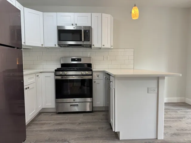 a kitchen with granite countertop a stove and a microwave