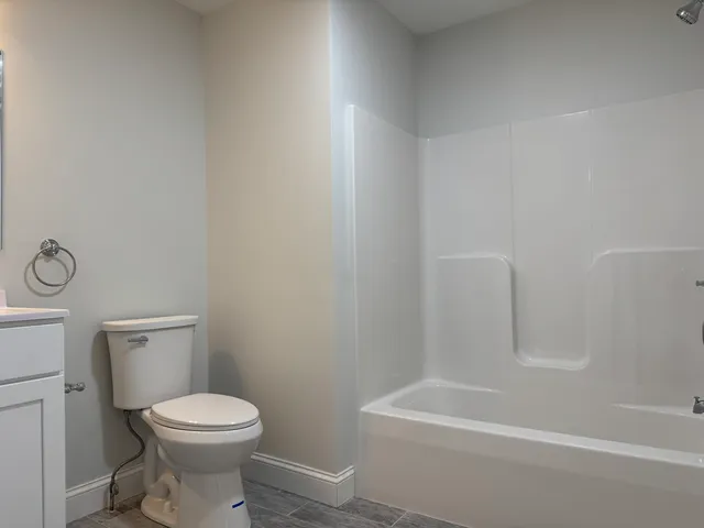 a white toilet sitting next to a bath tub