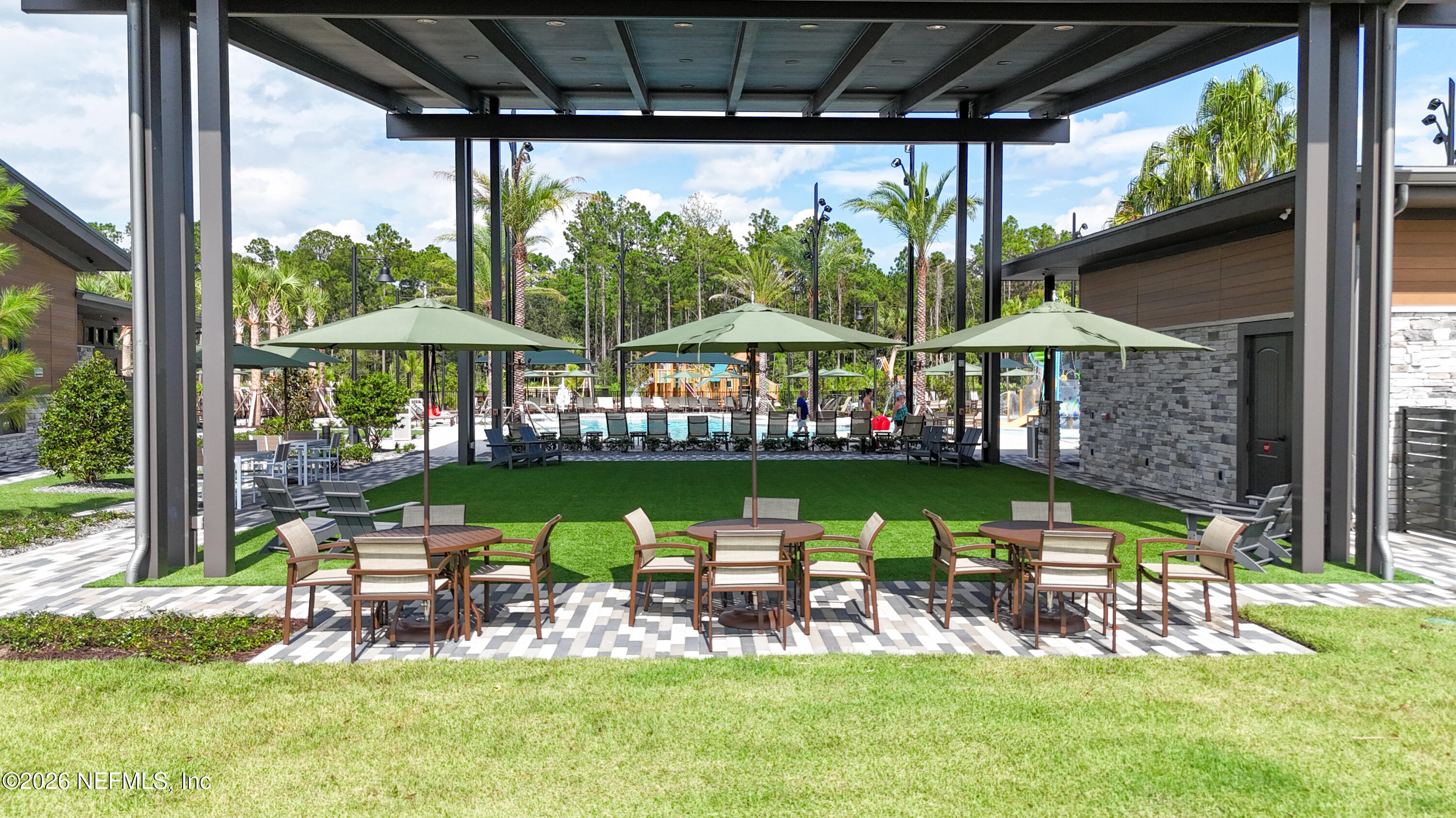 103 Riva Ridge Place St. Johns, FL 32259 - Photo 62 of 77 a view of a chairs and table in a patio with a table and chairs under an umbrella