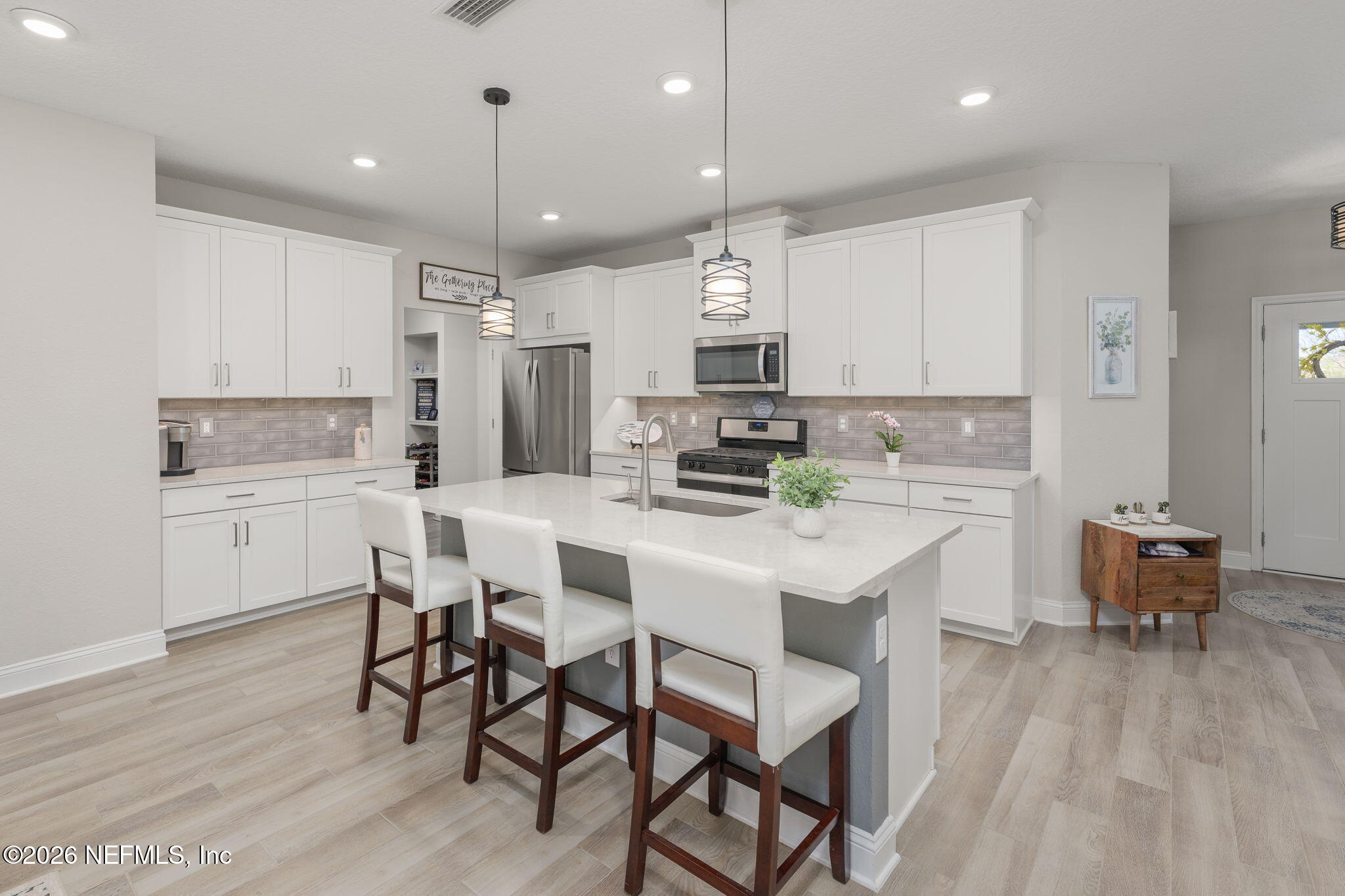 103 Riva Ridge Place St. Johns, FL 32259 - Photo 7 of 77 a kitchen with kitchen island white cabinets and stainless steel appliances