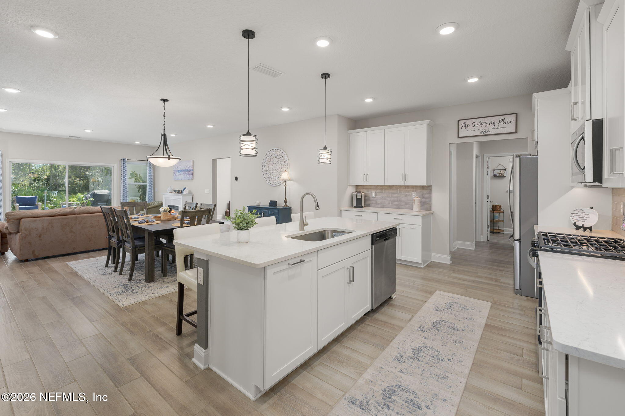 103 Riva Ridge Place St. Johns, FL 32259 - Photo 8 of 77 a large kitchen with kitchen island a island a sink a stove a refrigerator and a dining table with wooden floor
