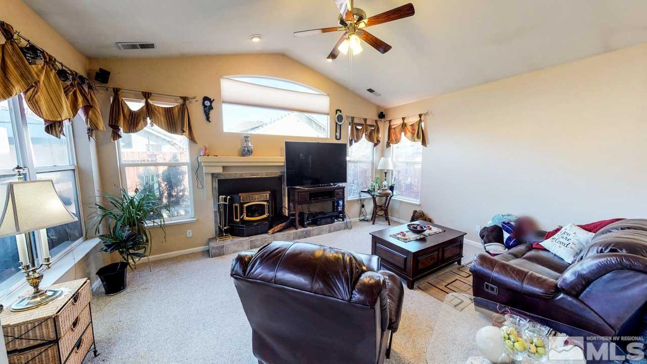 9980 Bandana Way Reno, NV 89521 - Photo 5 of 25 a living room with furniture a fireplace and a flat screen tv