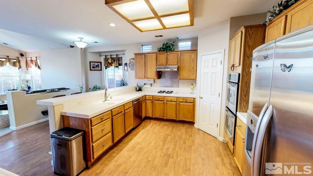 9980 Bandana Way Reno, NV 89521 - Photo 9 of 25 a large kitchen with stainless steel appliances a sink and refrigerator