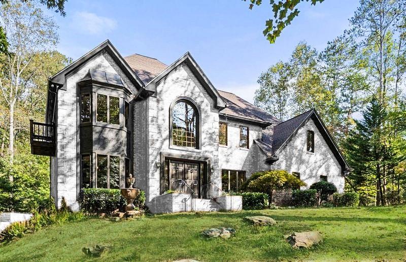 a front view of a house with a garden and plants