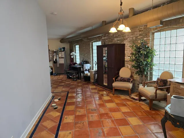 a living room with furniture a chandelier and a rug