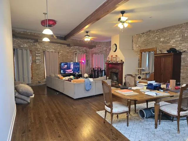 a living room with furniture a chandelier and a wooden floor