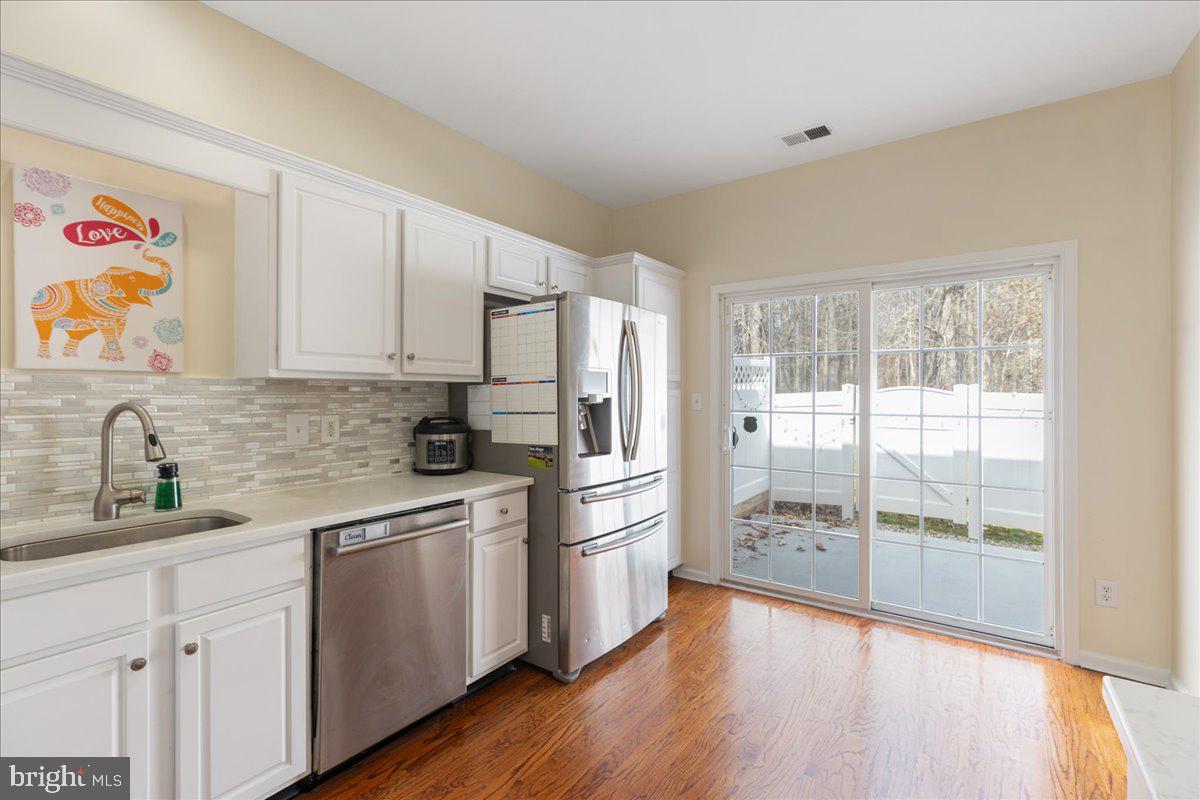 111 Windsor Pond Road Princeton Junction, NJ 08550 - Photo 10 of 29 a kitchen with a refrigerator a sink and wooden floor
