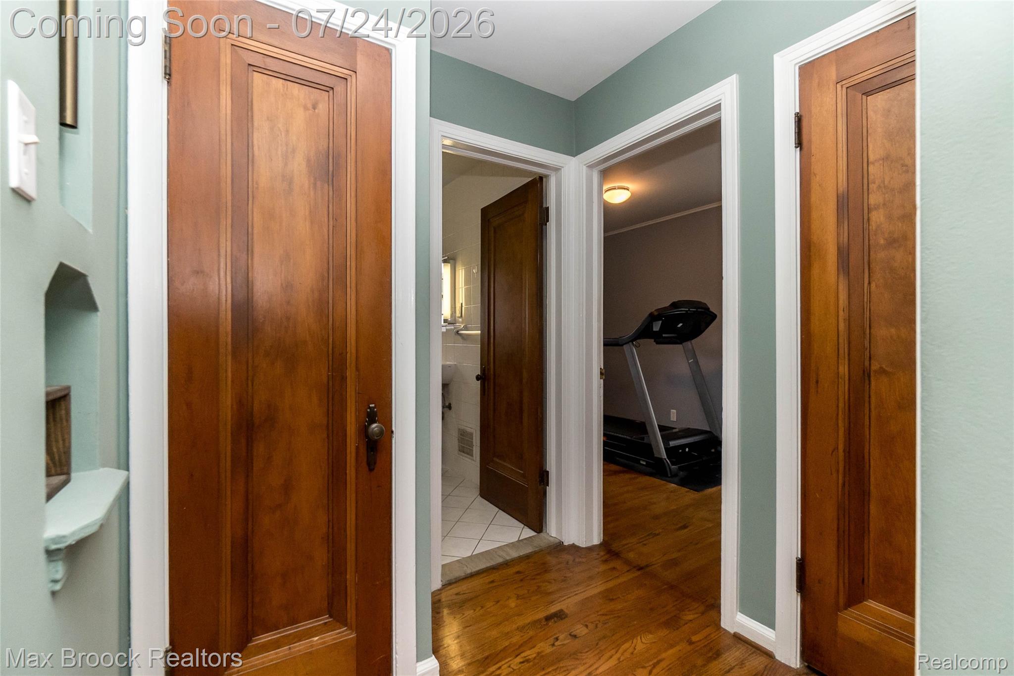 1090 Cambridge Road Berkley, MI 48072 - Photo 10 of 43 Hallway featuring wood-finish flooring, light teal wall paint, white trim, and solid wood panel doors