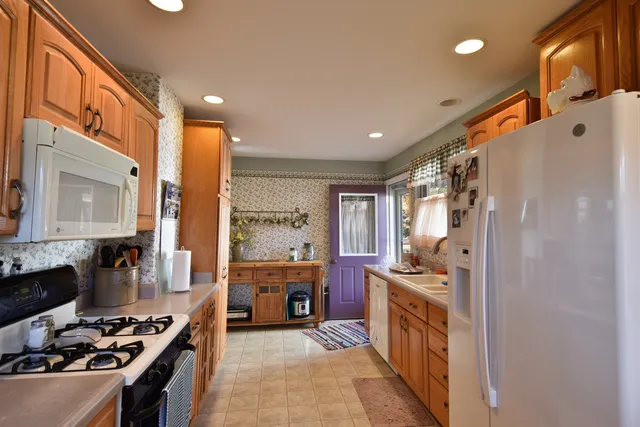 a kitchen with stainless steel appliances a sink a stove a refrigerator and cabinets