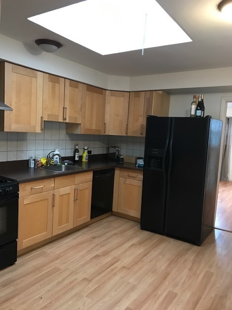 2011 West Roscoe Street Chicago, IL 60618 - Photo 6 of 8 a kitchen with a refrigerator sink and cabinets