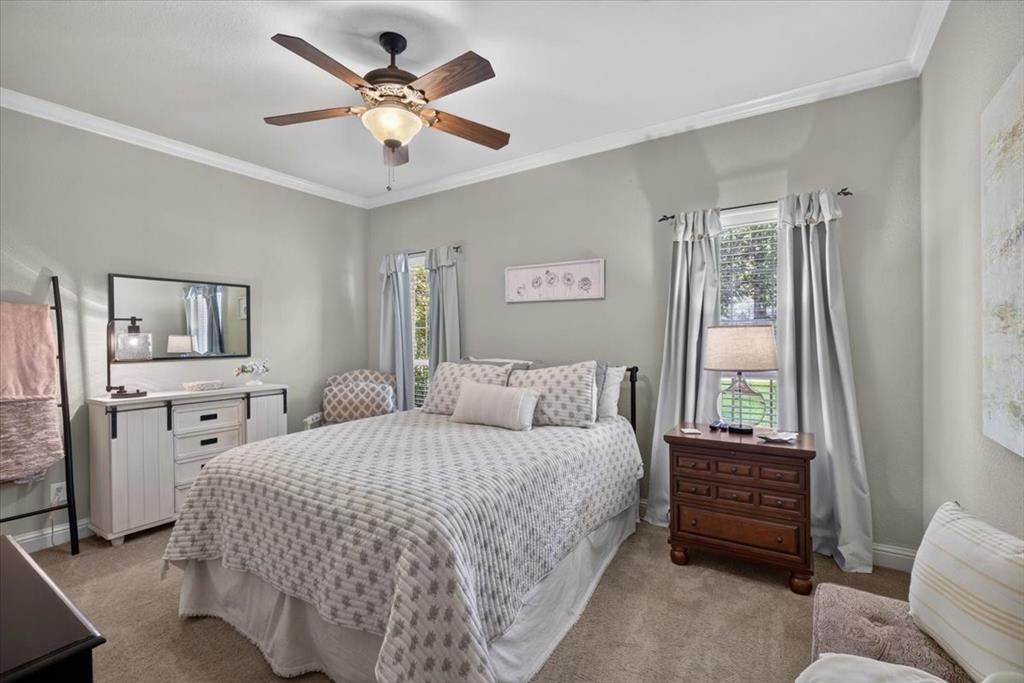 111 Trailwood Road Enchanted Oaks, TX 75156 - Photo 21 of 33 a bedroom with a bed a dresser and a chandelier