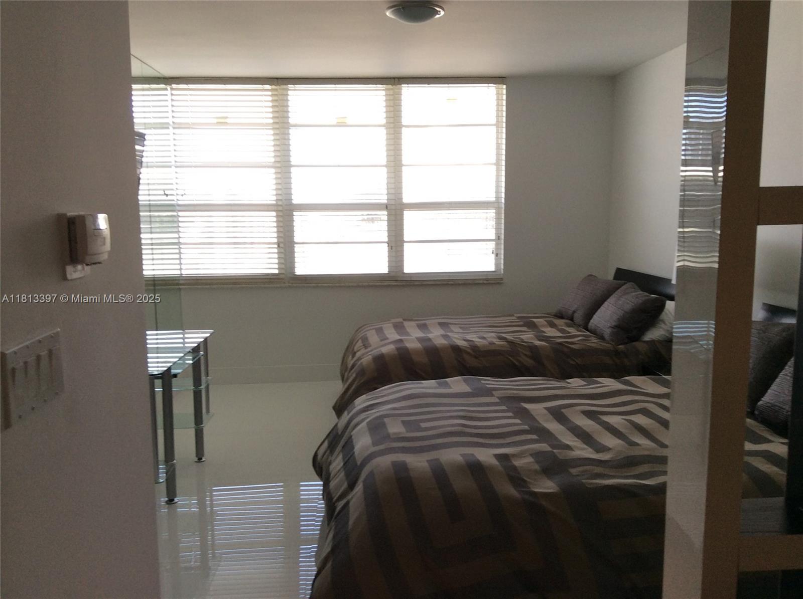 100 Lincoln Road, Unit 1214 Miami Beach, FL 33139 - Photo 14 of 17 a bed sitting in a bedroom next to a window