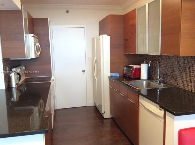 a kitchen with a refrigerator and a sink