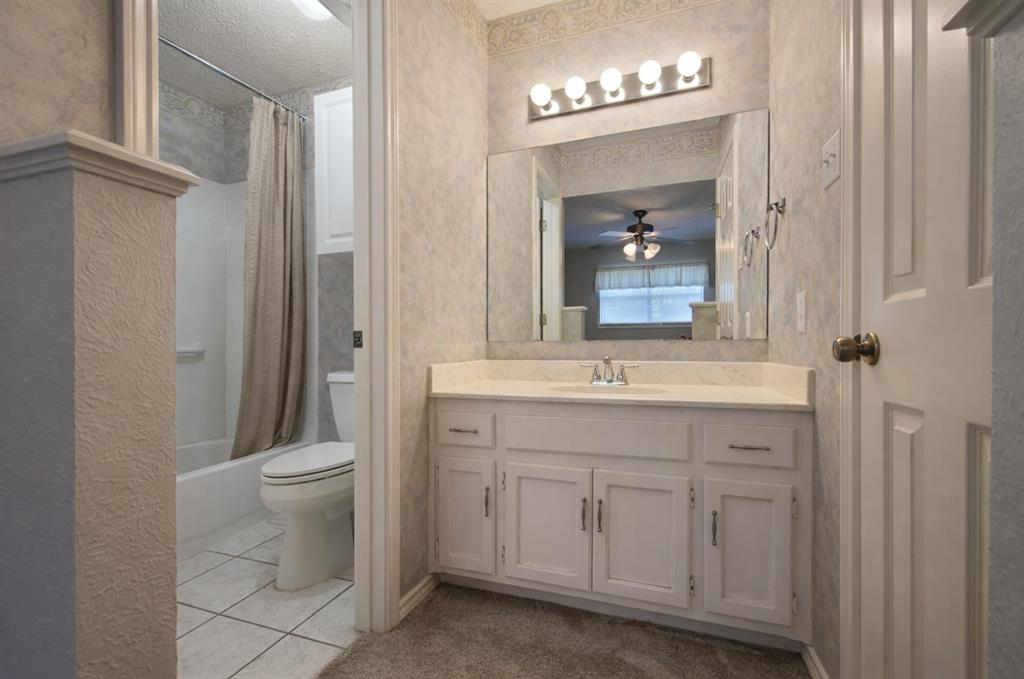 2302 Shiloh Street Denison, TX 75020 - Photo 13 of 16 a bathroom with a toilet a sink and mirror