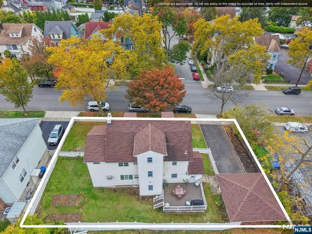 a view of a brick house with a small yard and large tree