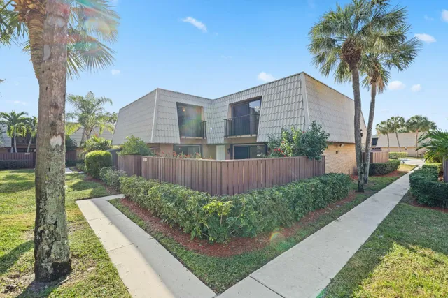 a front view of a house with a yard and potted plants