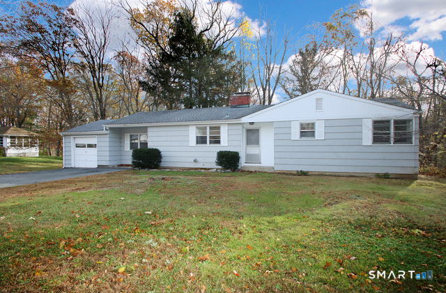 a front view of house with yard and trees