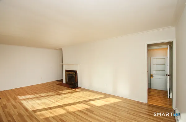 a big room with wooden floor and bathroom view