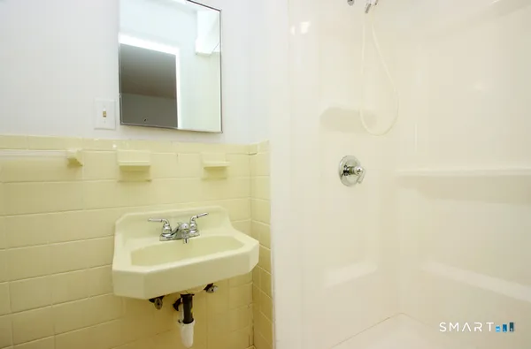 a bathroom with a sink a mirror and shower