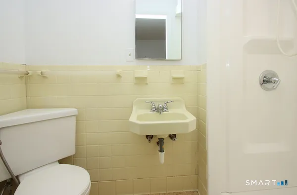 a bathroom with a toilet sink and mirror