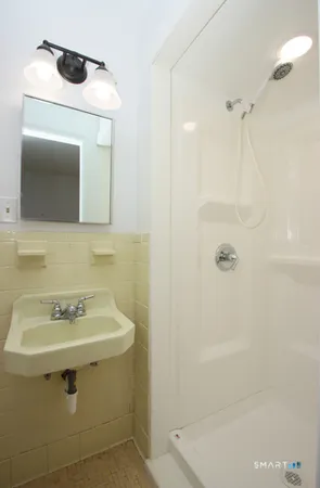 a bathroom with a sink a mirror and shower