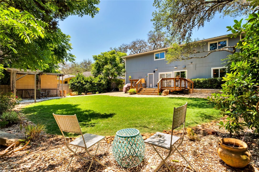 a view of a chair and table in backyard of the house
