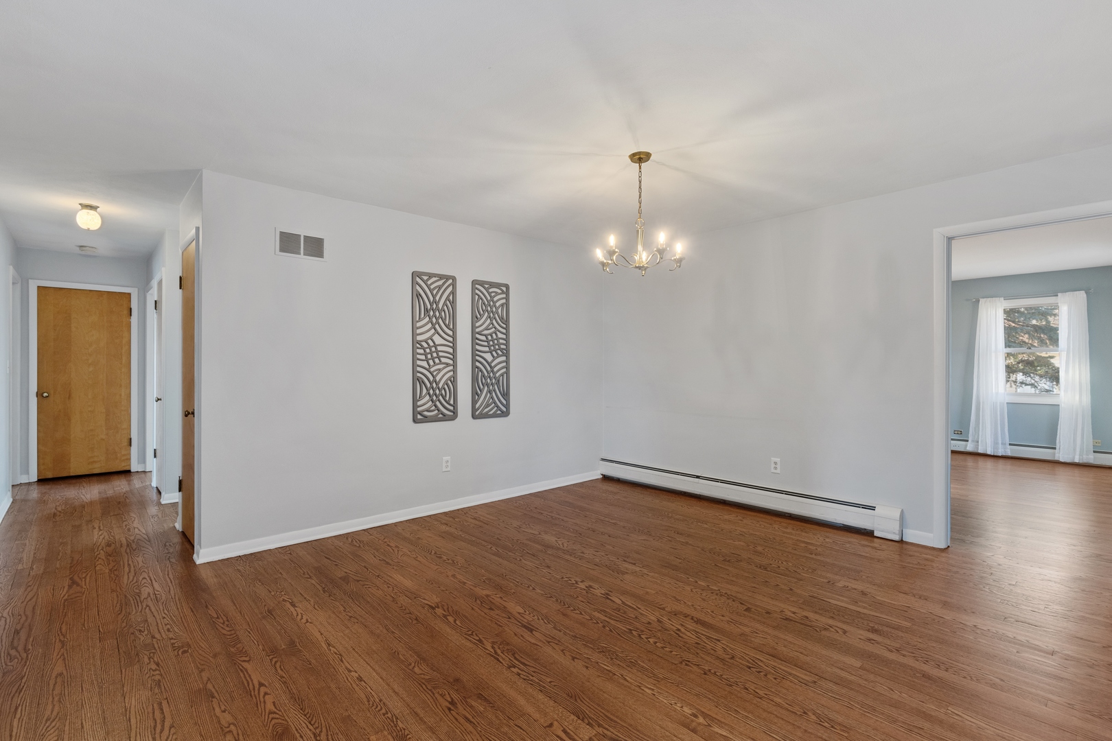 26075 Riverview Drive Antioch, IL 60002 - Photo 12 of 41 an empty room with wooden floor chandelier and windows